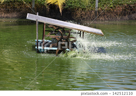 Solar-Powered Paddle Wheel Aerator Splashing Water in Fish Pond, Thailand Solar-Powered Paddle Wheel Aerator Splashing Water in Fish Pond, Thailand 142512110