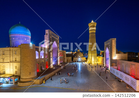 The beautifully illuminated Poi Kalyan Mosque and minaret at night in Bukhara, Uzbekistan. The beautifully illuminated Poi Kalyan Mosque and minaret at night in Bukhara, Uzbekistan. 142512206