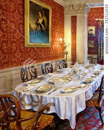 Grand Dining Table Setting in Stately Room with Red Damask Wallpaper Grand Dining Table Setting in Stately Room with Red Damask Wallpaper 142512410