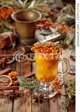 Warm sea buckthorn tea with fresh berries and thyme. Warm sea buckthorn tea with fresh berries and thyme. 142512719