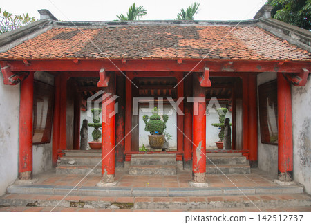 An old gate with red pillars and roof in the grounds of the Temple of Literature in Hanoi, Vietnam. This is the oldest university in Vietnam. An old gate with red pillars and roof in the grounds of the Temple of Literature in Hanoi, Vietnam. This is the oldest university in Vietnam. 142512737