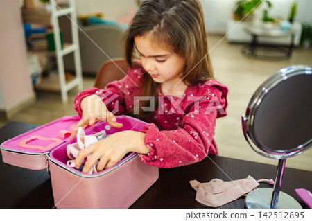 Little girl playing with her mother's makeup at home Little girl playing with her mother's makeup at home 142512895