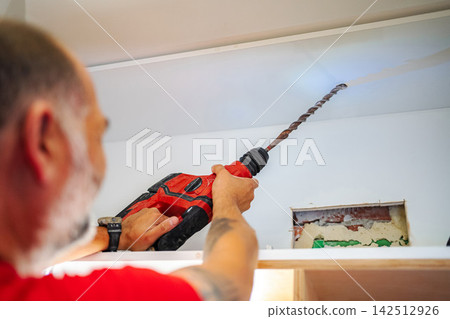 Man using hammer drill tool for home renovation project Man using hammer drill tool for home renovation project 142512926