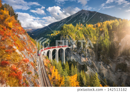 Aerial view of modern red train on Landwasser viaduct Aerial view of modern red train on Landwasser viaduct 142513182