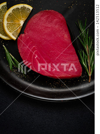 fresh red tuna fillet, for steak, raw, top view, on a black plate , no people, fresh red tuna fillet, for steak, raw, top view, on a black plate , no people, 142513512