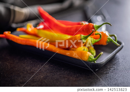 Colorful Red and Orange Chili Peppers on Tray With Kitchen Knife Close-Up 142513823
