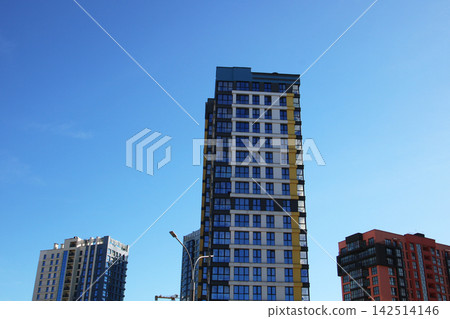 A very tall building standing majestically with a blue sky behind it A very tall building standing majestically with a blue sky behind it 142514146