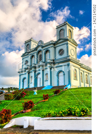 Scenic view of the Notre-Dame de l'Assomption church on a grassy hill under a cloudy blue sky in Sainte-Marie, Martinique, Caribbean France Scenic view of the Notre-Dame de l'Assomption church on a grassy hill under a cloudy blue sky in Sainte-Marie, Martinique, Caribbean France 142514502