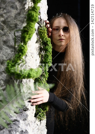 Young writer with reflective mood near aged mosscovered opening Young writer with reflective mood near aged mosscovered opening 142514719