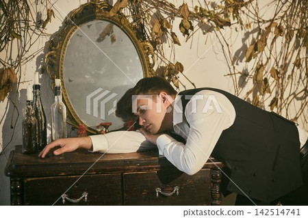 Man pondering within vintage room decorated with faded vines Man pondering within vintage room decorated with faded vines 142514741