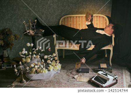 Person dressed in formal wear appears drained by cluttered workspace Person dressed in formal wear appears drained by cluttered workspace 142514744