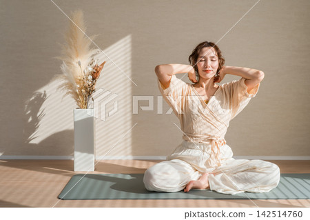 一位四十多歲的女性在晨光中伸展身體,這是她保持身心健康的習慣。 一位四十多歲的女性在晨光中伸展身體,這是她保持身心健康的習慣。 142514760