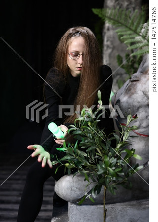 Caucasian scientist adjusts energy tool on houseplant with precision Caucasian scientist adjusts energy tool on houseplant with precision 142514766