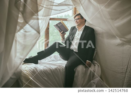 Contemplative man in suit enjoying quiet moment indoors Contemplative man in suit enjoying quiet moment indoors 142514768
