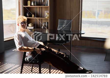 Young man concentrated on his laptop amid bright sunlight Young man concentrated on his laptop amid bright sunlight 142514769