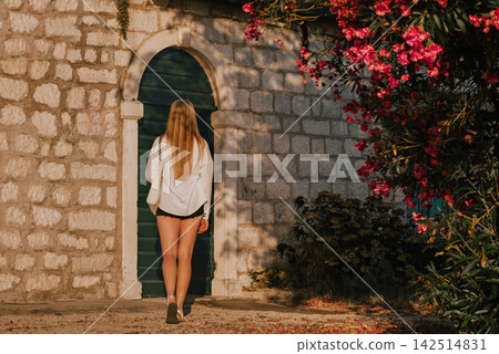 Woman Walking toward Door of Stone House Woman Walking toward Door of Stone House 142514831