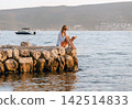 Local European Woman Reading Paper Book on Pier 142514833
