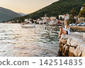 Woman Reading Paper Book on Stone Pier 142514835