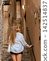 Local European Woman Walking up Stone Stairs 142514837