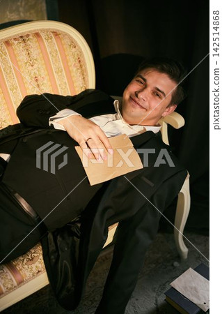 Contemplative man in vintage attire writing in cozy room Contemplative man in vintage attire writing in cozy room 142514868