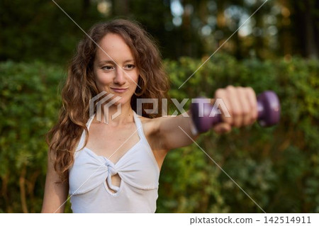 Female athlete focusing during workout in public park setting Female athlete focusing during workout in public park setting 142514911