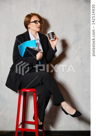 Relaxed businesswoman sitting on stool during casual meeting break Relaxed businesswoman sitting on stool during casual meeting break 142514930