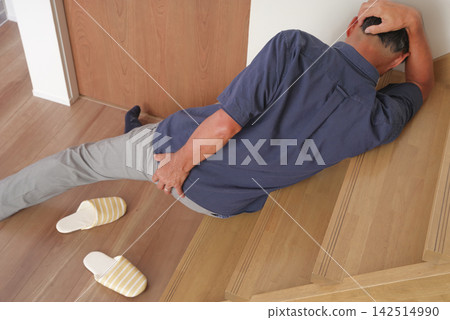 A senior man injured his lower back after falling down the stairs. A senior man injured his lower back after falling down the stairs. 142514990