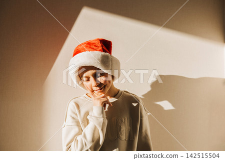 Boy wearing a Santa hat in warm sunlight Boy wearing a Santa hat in warm sunlight 142515504