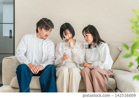 A family of three becomes anxious after seeing negative reviews and low ratings for a smartphone; parents and children check the reputation. A family of three becomes anxious after seeing negative reviews and low ratings for a smartphone; parents and children check the reputation. 142516809