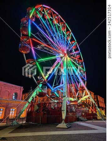 Illuminated Ferris Wheel with Colorful Rainbow LED Lights at Christmas Night on City Square Illuminated Ferris Wheel with Colorful Rainbow LED Lights at Christmas Night on City Square 142517314