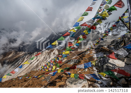 Prayer flags pole on the top of Tsergo Ri (4,990m) the high point on the Langtang valley trek of Nepal. The prayer flags initiate peace and good tidings, their sacred mantras etched on the wind. Prayer flags pole on the top of Tsergo Ri (4,990m) the high point on the Langtang valley trek of Nepal. The prayer flags initiate peace and good tidings, their sacred mantras etched on the wind. 142517318