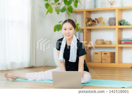 Young woman doing yoga in the living room Young woman doing yoga in the living room 142518001