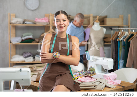 Young woman posing male assistant working with mannequin in workshop Young woman posing male assistant working with mannequin in workshop 142518286