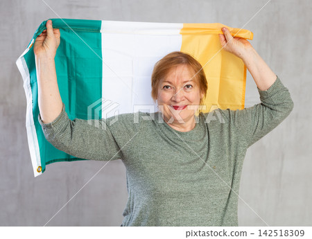 Cheerful senior woman standing confidently with irish flag Cheerful senior woman standing confidently with irish flag 142518309
