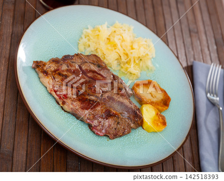 Grilled beef piece, potatoes and sauerkraut served in a plate Grilled beef piece, potatoes and sauerkraut served in a plate 142518393