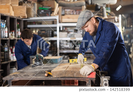 Experienced carpenter measures the length of board using tape measure. Preparing to cut board Experienced carpenter measures the length of board using tape measure. Preparing to cut board 142518399