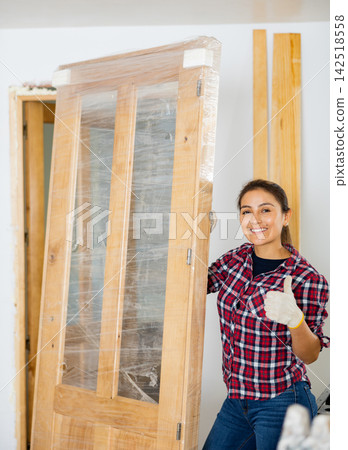 Portrait of positive woman with new door in apartment Portrait of positive woman with new door in apartment 142518558