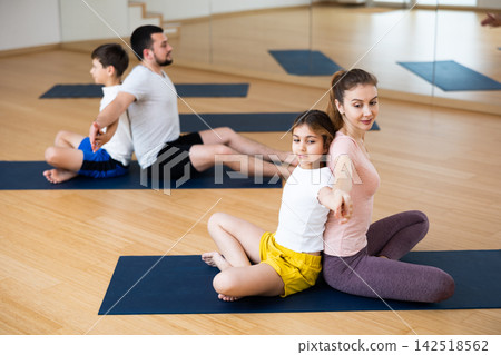 Family practicing yoga in pairs at studio Family practicing yoga in pairs at studio 142518562