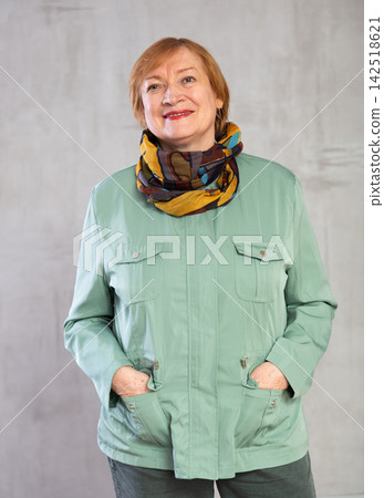 Happy mature lady in winter clothes standing with confident radiant smile Happy mature lady in winter clothes standing with confident radiant smile 142518621