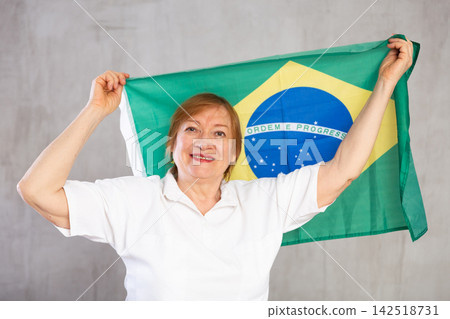 Cheerful senior woman standing confidently with brazilian flag Cheerful senior woman standing confidently with brazilian flag 142518731