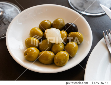 Light snack - oval bowl with pickled green olives and small onion 142518735