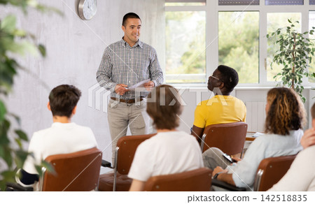 Young man teacher reading lecture for a group of guys Young man teacher reading lecture for a group of guys 142518835