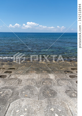 海岸線有階梯式防波堤,視野開闊,可以清楚地看到蔚藍的天空和清晰的地平線。 海岸線有階梯式防波堤,視野開闊,可以清楚地看到蔚藍的天空和清晰的地平線。 142518944