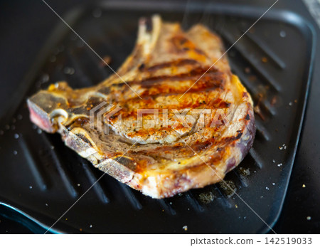 Medium rare fried entrecote beef steak in cast iron pan with salt and pepper closeup Medium rare fried entrecote beef steak in cast iron pan with salt and pepper closeup 142519033