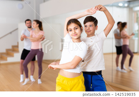 Siblings practicing active dance in pairs Siblings practicing active dance in pairs 142519035