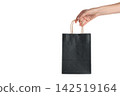 Black Friday. Hand gripping black shopping bag filled with treasures from shopping spree, PNG 142519164