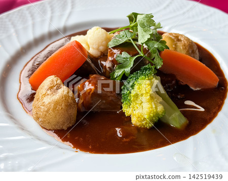 Beef stew with beef and vegetables. It contains chunky pieces of carrots, potatoes, broccoli, and beef. 142519439
