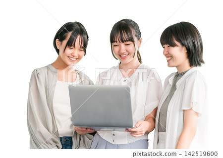 Elementary and junior high school girls in casual clothes happily looking at a computer with their friends Elementary and junior high school girls in casual clothes happily looking at a computer with their friends 142519600