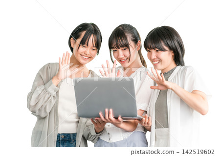 Elementary and junior high school girls in casual clothes happily looking at a computer with their friends Elementary and junior high school girls in casual clothes happily looking at a computer with their friends 142519602