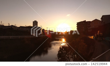 Watching the sunset from the riverbank at the end of the day. Watching the sunset from the riverbank at the end of the day. 142519944